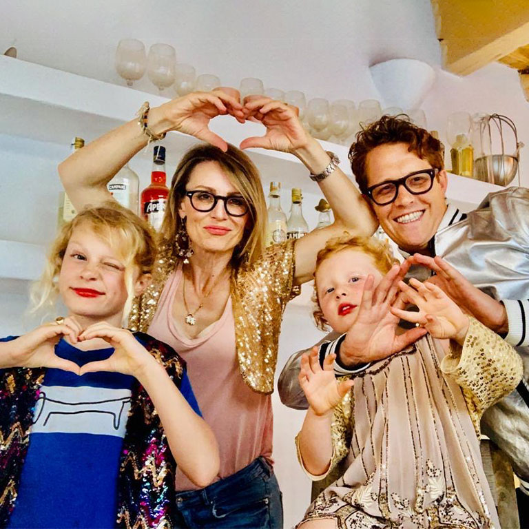 Family dressed up making hearts.