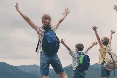 Image of a family at the top of a mountain with their arms stretched out