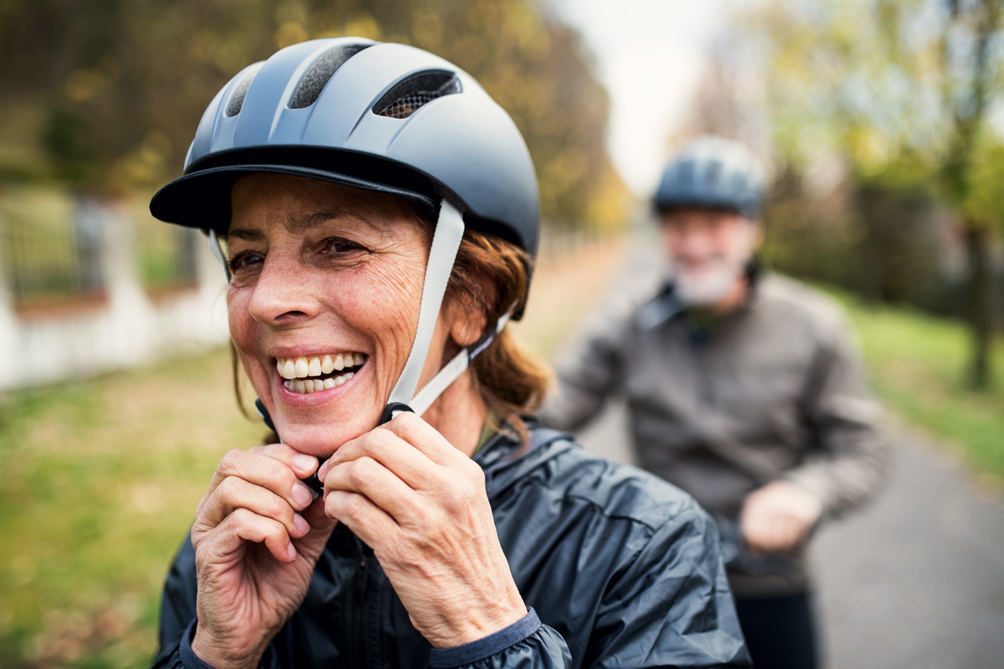 Older woman adjusting bicycle helmet